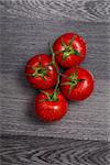 Fresh tasty tomatoes on gray table background