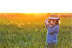 Little boy with a camera in the field