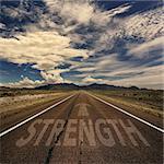 Conceptual image of desert road with the word strength and arrow