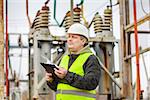 Electrical Engineer with folder in electrical substation