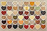 Dried super health food in heart shaped bowls over hessian background. High in minerals, vitamins and antioxidants.