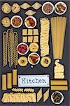 Large dried italian pasta food sampler with old metal kitchen sign on grey background.