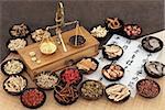 Chinese medicine ingredients with scales and calligraphy on rice paper. Translation read as chinese herbal medicine as increasing the bodys ability to maintain body and spirit health and balance energy.