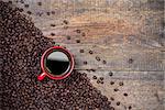 Coffee beans and red coffee cup on wooden background