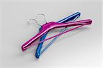 Purple and blue coat hangers on gray background