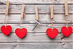 Hearts and key hanging on a string, shot on wooden background