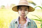 Portrait of a mature Burmese female farmer with thanaka powdered face who works in the field.