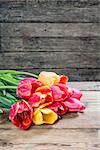 Lovely tulip flowers on wooden table, rustic design