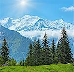 Mont Blanc mountain massif with sunshine in blue sky (Chamonix valley, France, view from Plaine Joux outskirts).