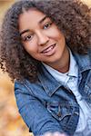 Outdoor portrait of beautiful happy mixed race African American girl teenager female child smiling with perfect teeth