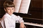 Young Boy playing the piano with sheet music. Boy piano.Piano player.