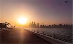 empty boardwalk in the morning sun with the skyline of Dubai in the background, Dubai, UAE