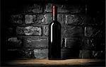 Bottle of wine near wall of black bricks