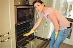 Woman cleaning the oven at home