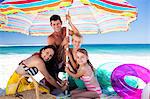 Cute family setting their umbrella on the beach