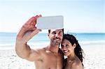 Cute couple taking selfie on the beach