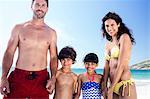 Cute family holding hands on the beach