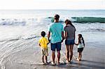 Cute family standing in the water on the beach