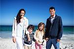 Cute family holding hands on the beach