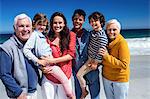 Cute family smiling at camera on the beach