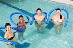 Pregnant women exercising with foam rollers at the swimming pool