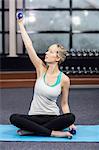 Blonde woman exercising with dumbbells at the leisure center