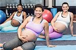 Pregnant woman doing exercise on mat at the leisure center