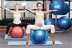 Pregnant woman exercising on fitness ball at the leisure center