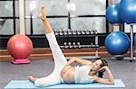 Pregnant woman doing exercise on mat at the leisure center