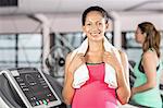 Smiling pregnant woman holding towel at the leisure center