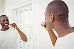 Handsome man about to brush his teeth in the bathroom