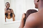 Man covering eyes of his girlfriend in the bathroom