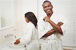 Ethnic couple wearing bathrobes in the bathroom