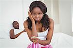 Worried woman waiting for pregnancy test result in her bedroom