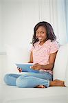 Woman using tablet computer on the couch