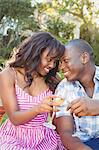 Ethnic couple toasting with champagne in the garden