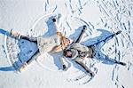 Couple doing snow angel on a beautiful snowy day