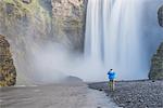 Tourist taking a photo of Skogafoss Waterfall, Skogar, South Region (Sudurland), Iceland, Polar Regions