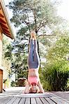 Young woman doing headstand in garden