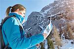 Young woman looking at map in Austrian mountains