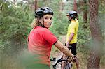 Mountain biking couple biking on forest trail