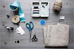 Overhead view of sewing equipment with textiles, threads and scissors