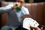 Male hand playing cards in traditional UK pub