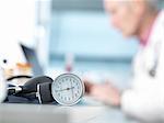 Blood pressure monitor on desk, doctor in background