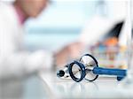 Stethoscope on desk, doctor in background