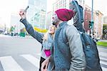 Couple taking selfie with smartphone on street