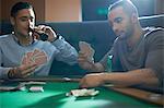 Men playing card game for cash at pub card table