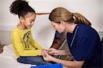 Doctor checking girls hand