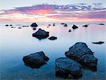 Rocks in sea at sunset