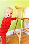 Baby standing near chair